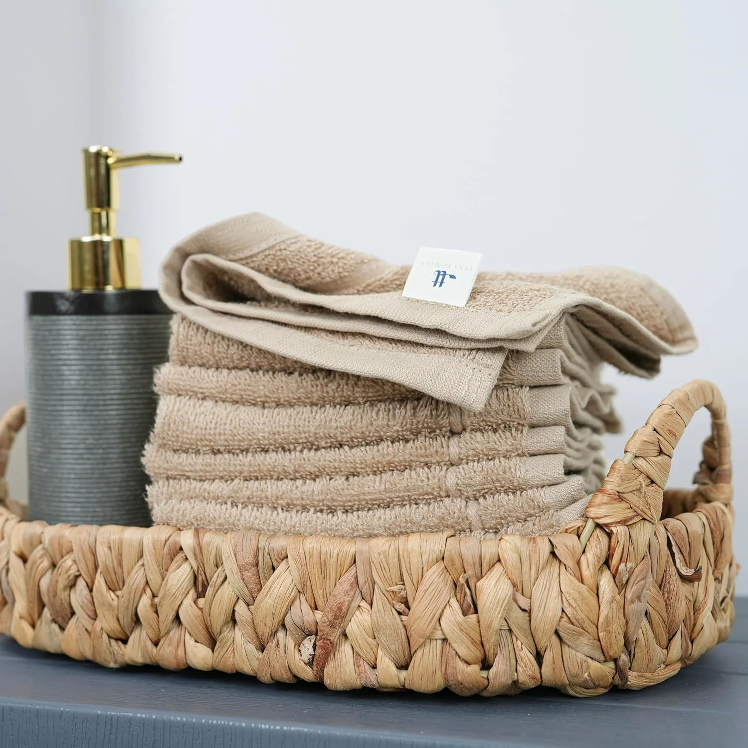 Beige towels folded into a woven basket