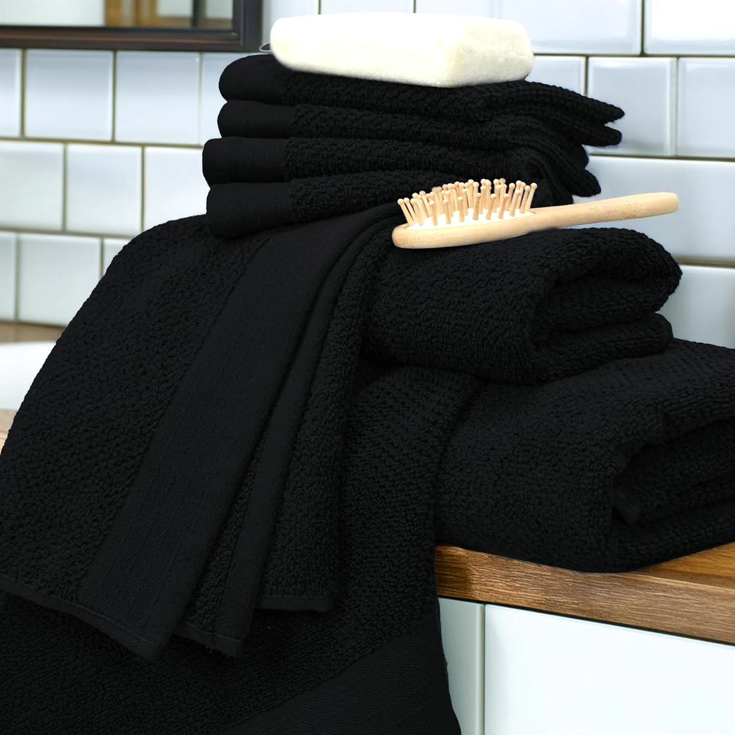 Black popcorn-weave towel set beside a basin