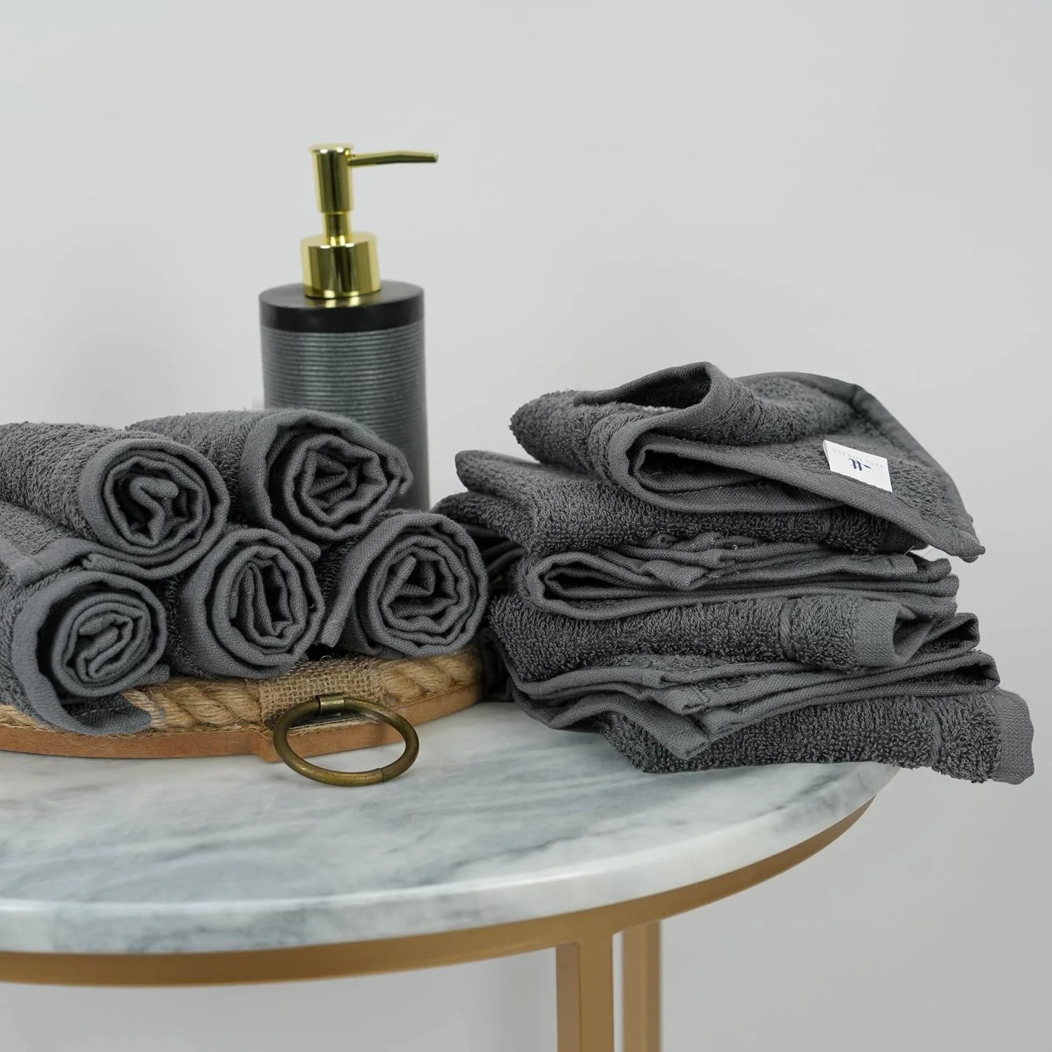 A dozen dark grey washcloths stacked in two columns