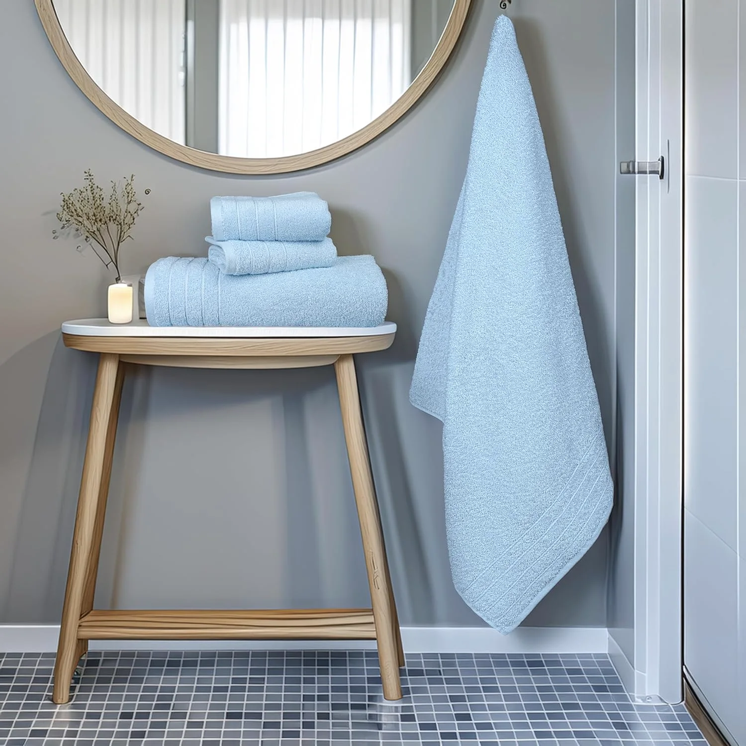 Sky blue towels beside a round mirror